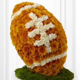 Orange and white chrysanthemum floral sculpture on a green base
