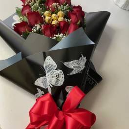 Bouquet of red roses wrapped in black paper with a red ribbon