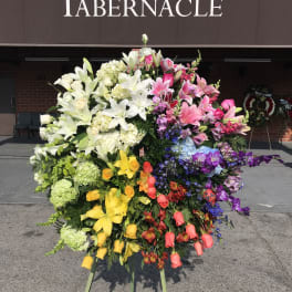 Large standing floral wreath with multicolored lilies and roses