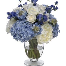 Blue and white flower arrangement in a clear glass vase