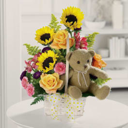 Basket arrangement with sunflowers, roses, and a teddy bear