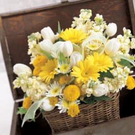 Yellow and white flowers arranged in a wicker basket