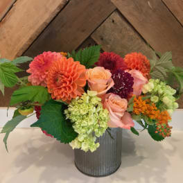 Colorful bouquet of dahlias, roses, and hydrangeas in a metal vase