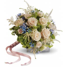 Handheld bouquet of cream roses with blue flowers and long pink ribbon tails