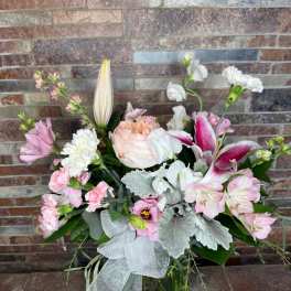 Pink and white mixed bouquet in a glass vase with a silver ribbon