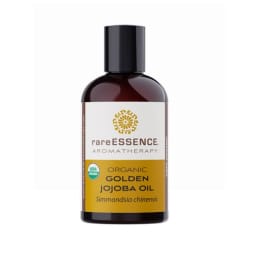 Bottle of organic golden jojoba oil with a black cap