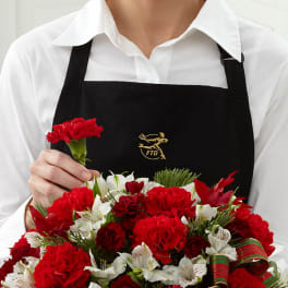 Person holding a red and white floral bouquet with a matching boutonniere