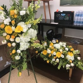 Large yellow and white floral standing spray with a matching low arrangement