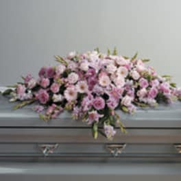 Pink floral casket spray on a gray casket