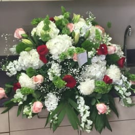 Large floral arrangement with white, pink, and red blooms in a container
