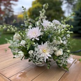 White and pale pink floral arrangement in a low vase