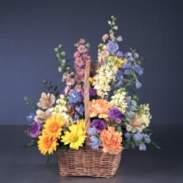Colorful mixed flower basket arrangement in a wicker basket