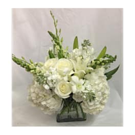 White floral arrangement in a square glass vase