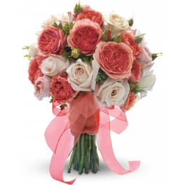 Hand-tied bouquet of peach and ivory roses wrapped with a sheer peach ribbon bow