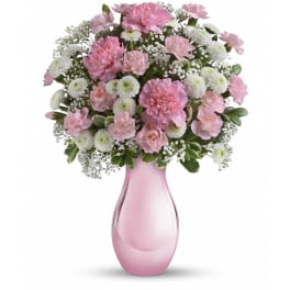 Pink and white carnation and mum arrangement in a light pink glass vase