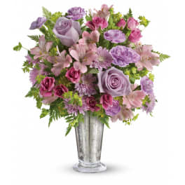 Lavender and pink roses, alstroemeria, and mums in a tall silver glass vase