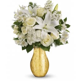 White lilies, roses, and carnations arranged in a gold metallic vase