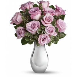 Lavender rose bouquet arranged in a silver-toned vase with small filler accents