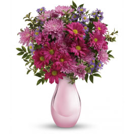 Pink and lavender chrysanthemums with purple asters in a pale pink glass vase