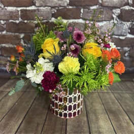Colorful mixed flower arrangement in a patterned vase