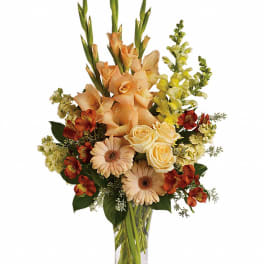 Peach and cream floral arrangement in a clear glass vase