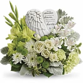 White and green sympathy arrangement with angel wings and a memorial plaque