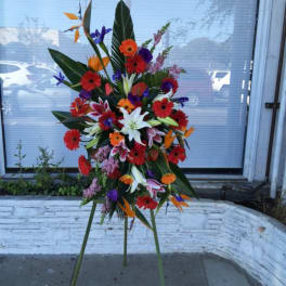 Tall tropical flower arrangement on a stand with bright mixed blooms
