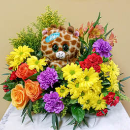 Colorful flower arrangement with a plush giraffe in the center
