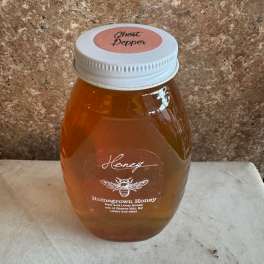 Jar of honey with a white lid on a countertop