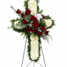 Standing floral cross with red roses and white chrysanthemums on an easel