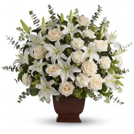 White lilies and cream roses arranged in a brown urn vase