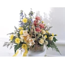 Basket arrangement with yellow and pink flowers and ribbon