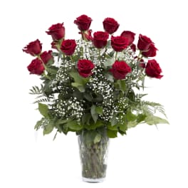 Red roses with baby's breath in a clear glass vase