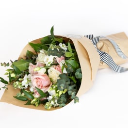 Bouquet of pink and white roses wrapped in kraft paper