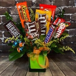 Candy bars arranged in a gift bouquet with ribbon in a green container