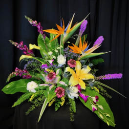 Tropical floral arrangement with bird-of-paradise, lilies, and purple spikes