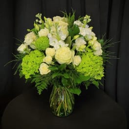 White roses and green hydrangeas in a glass vase