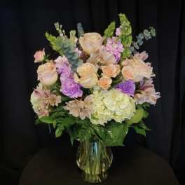 Pastel bouquet of roses, hydrangea, and alstroemeria in a glass vase