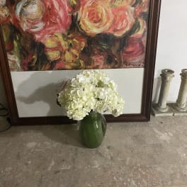 White hydrangea arrangement in a green vase