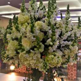 Large white and green floral arrangement with tall spikes and hydrangeas