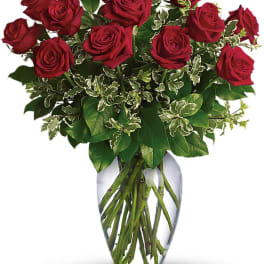 Red roses arranged in a clear glass vase