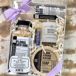 Gift box with floral bath products and a lavender ribbon