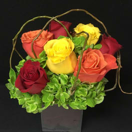 Bouquet of multicolored roses in a square vase