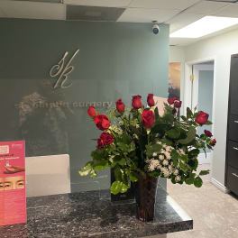 Red roses in a dark glass vase on a counter