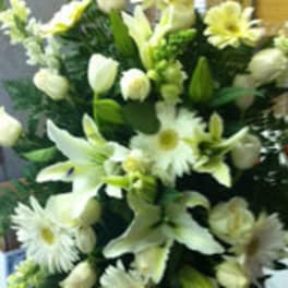 White floral arrangement with daisies, lilies, and roses