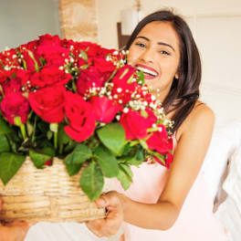 Woman holding a basket of red roses