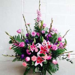 Tall pink and purple floral arrangement with lilies and roses