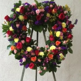 Colorful floral wreath on a stand with mixed roses and small blooms