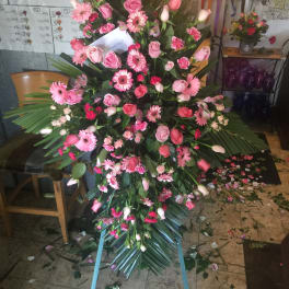 Large pink floral standing spray with roses, gerbera daisies, and tulips