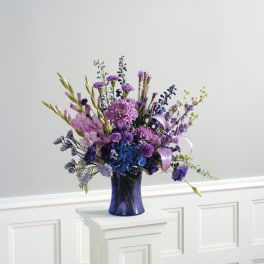 Purple and blue floral arrangement in a dark blue vase
